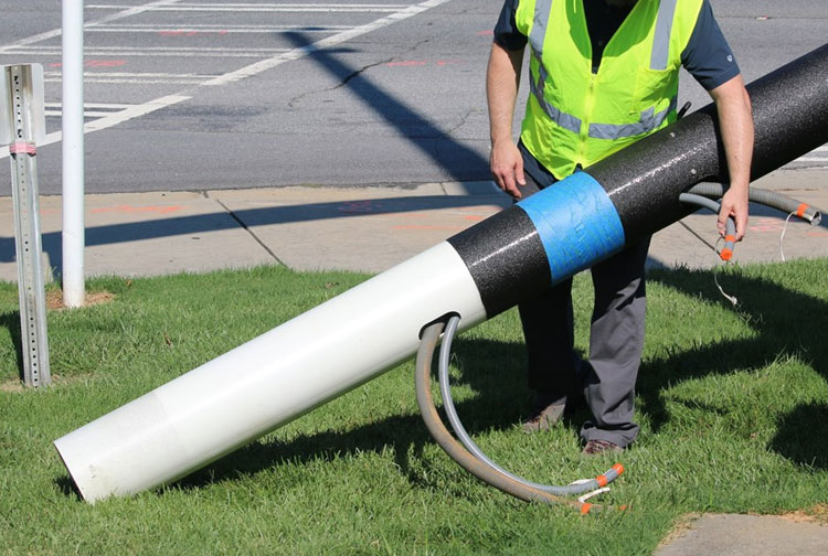 Composite utility pole being installed in a rural setting