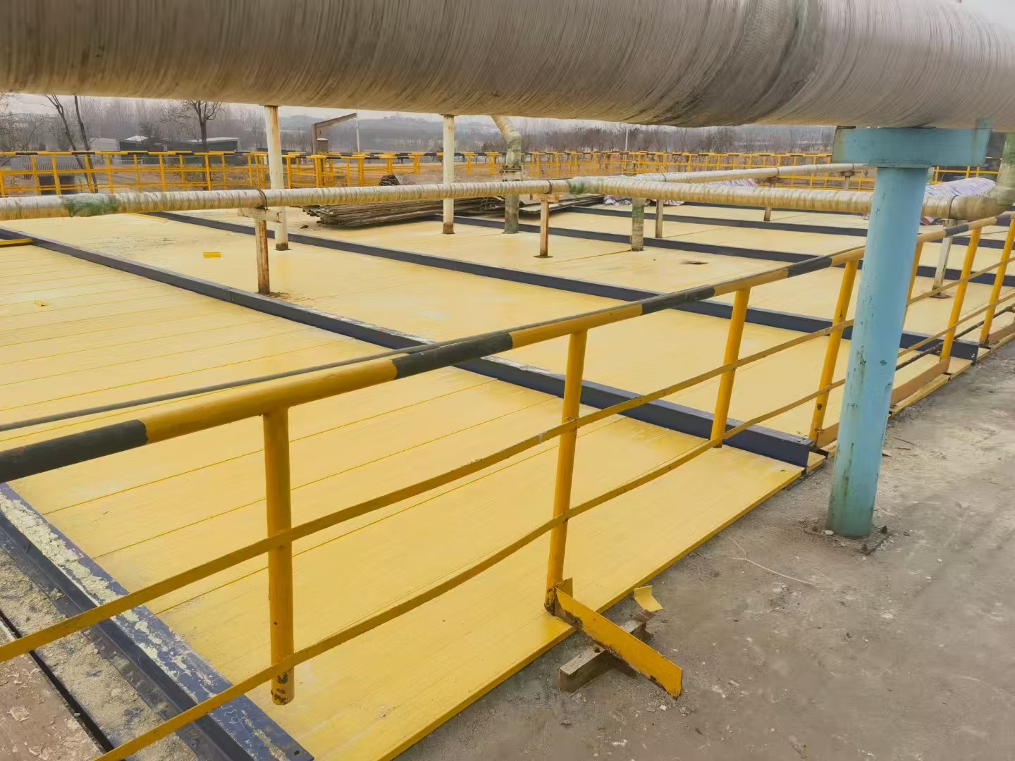 Yellow FRP cover plates installed as platform walkway at a treatment plant