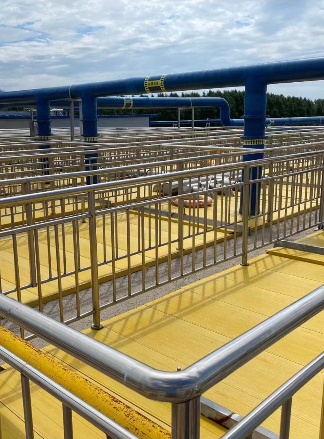 Yellow FRP cover plates installed at a large treatment facility with railings